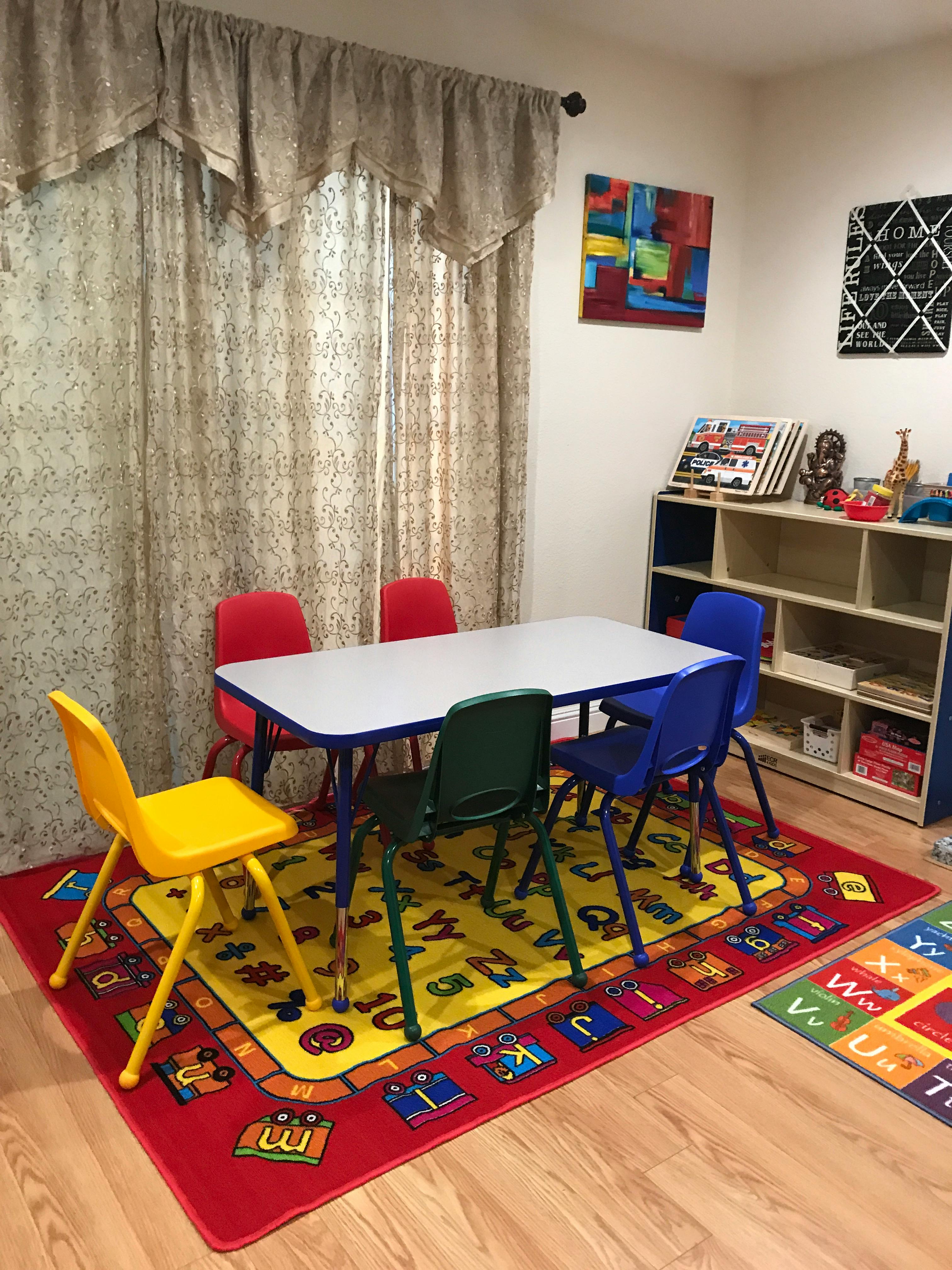 Children's table and chairs on an alphabet rug in a classroom