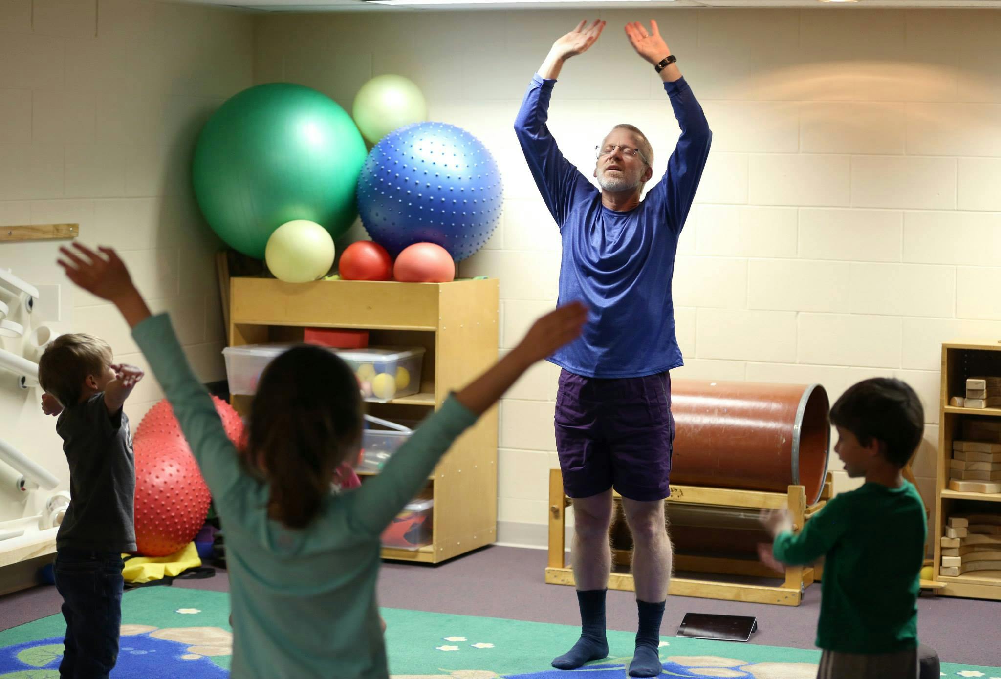 Adult and children doing exercises with arms raised