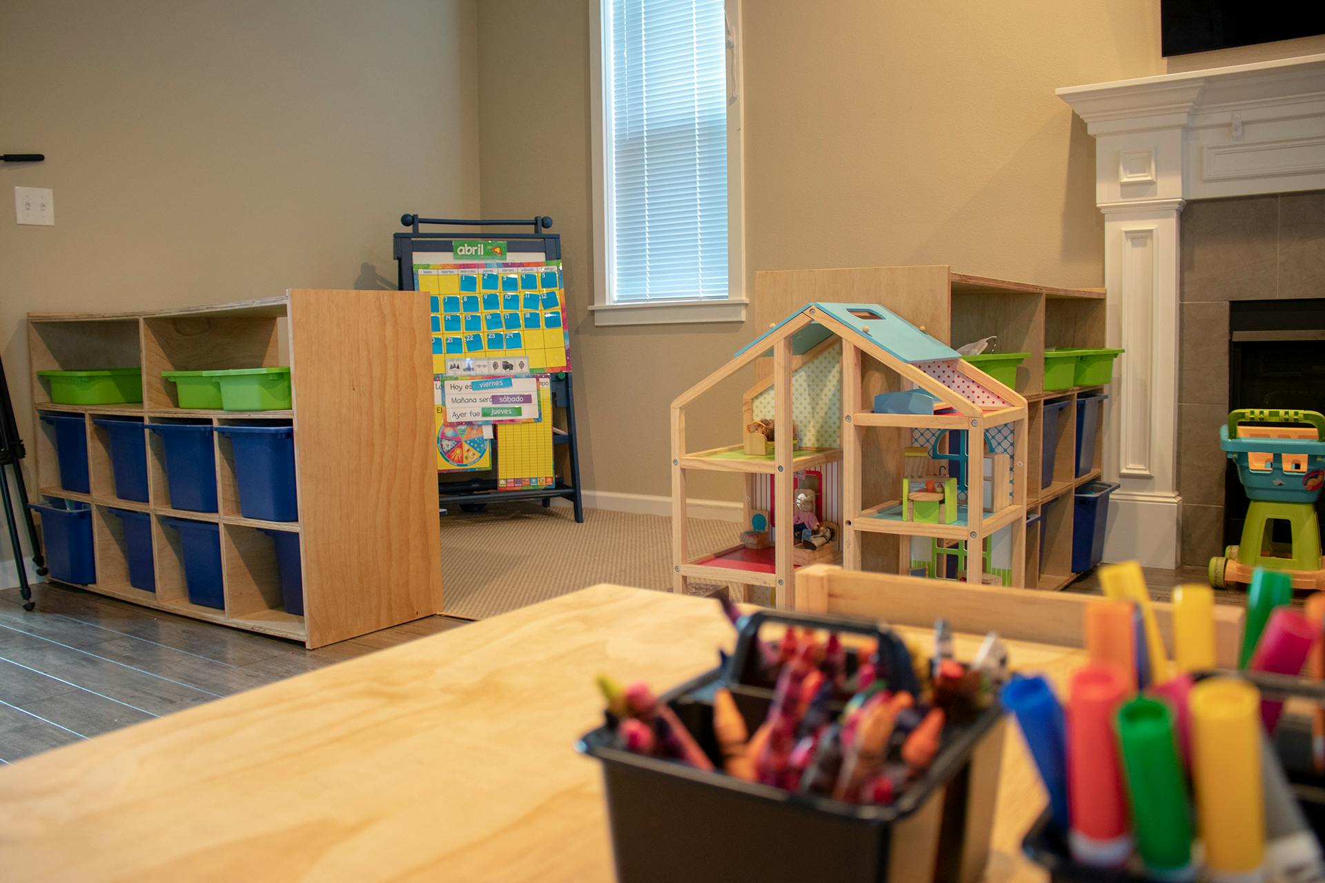 Classroom with storage shelves, dollhouse, and art supplies