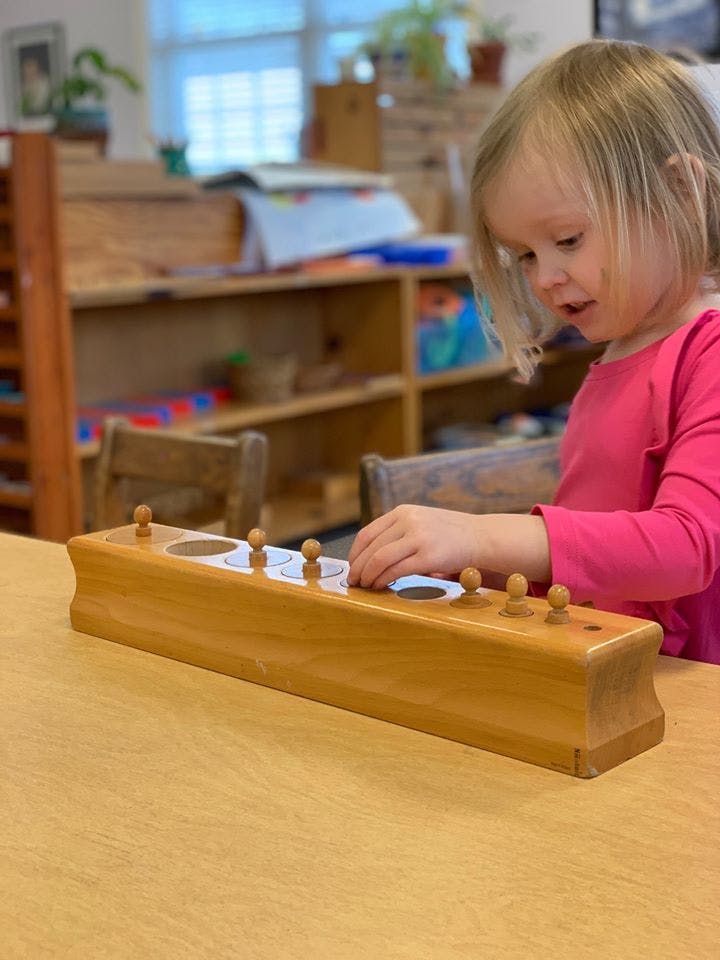 Child playing with a wooden puzzle toy