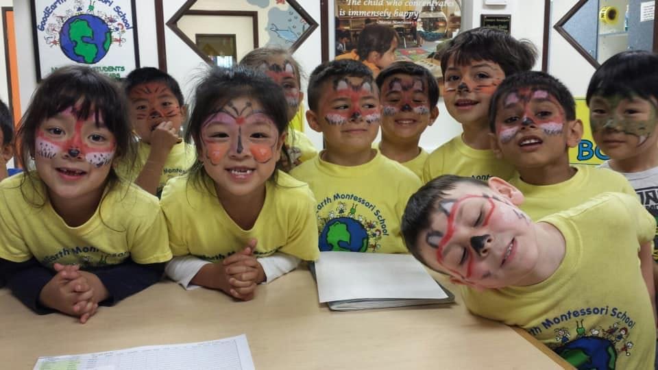 Group of children with painted faces in a classroom