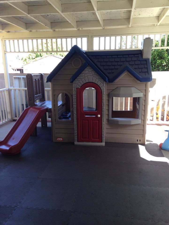 Playhouse with a red door and a red slide attached