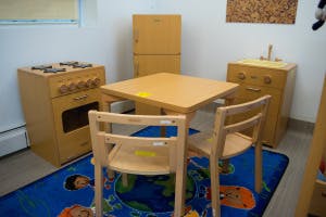 Play kitchen with toy stove, sink, table, and chairs