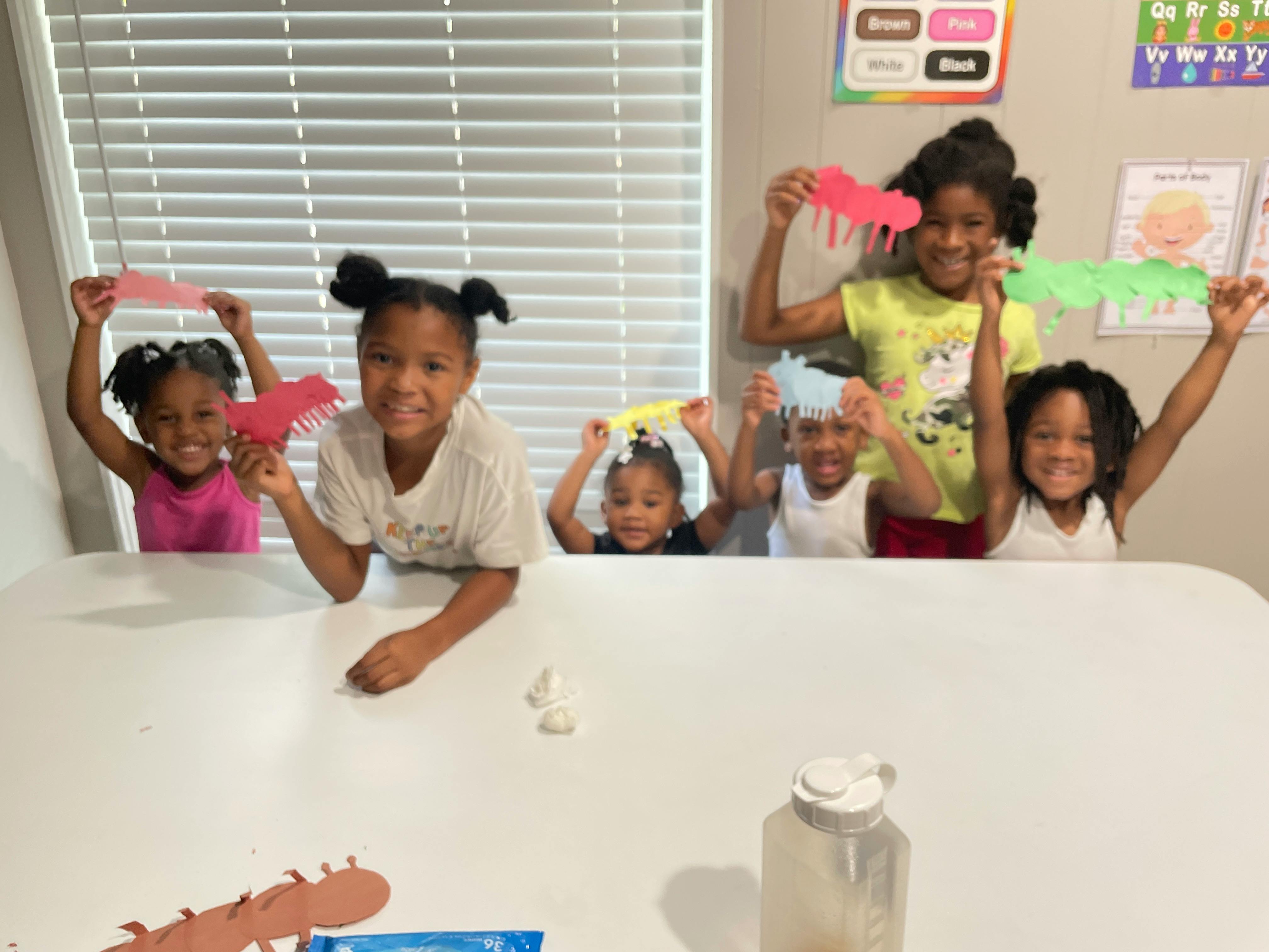 Group of children holding up paper cutouts