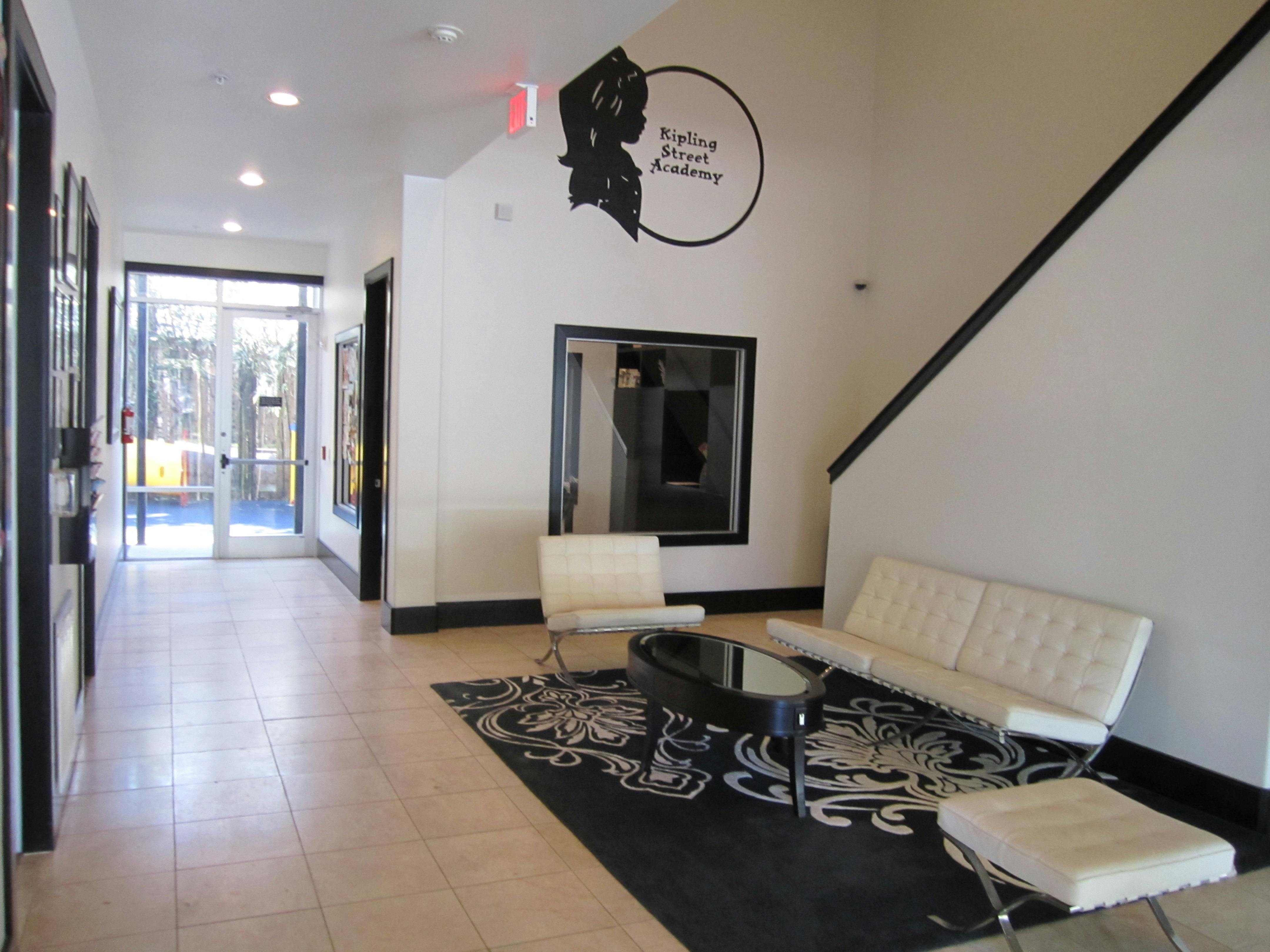 Lobby with white sofa and chairs, black coffee table, and patterned rug