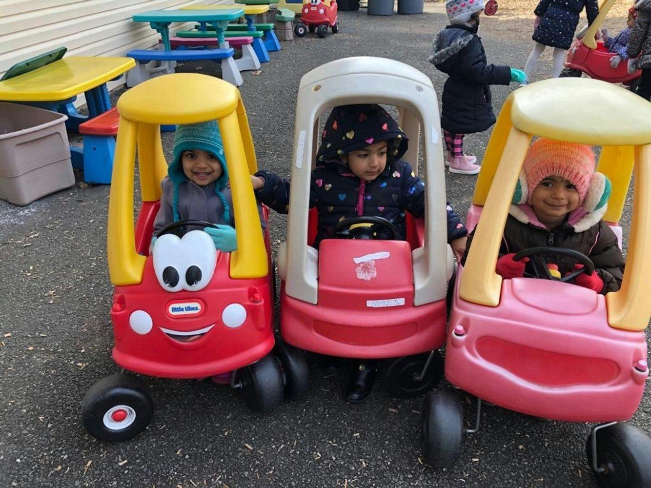 Three children in toy cars