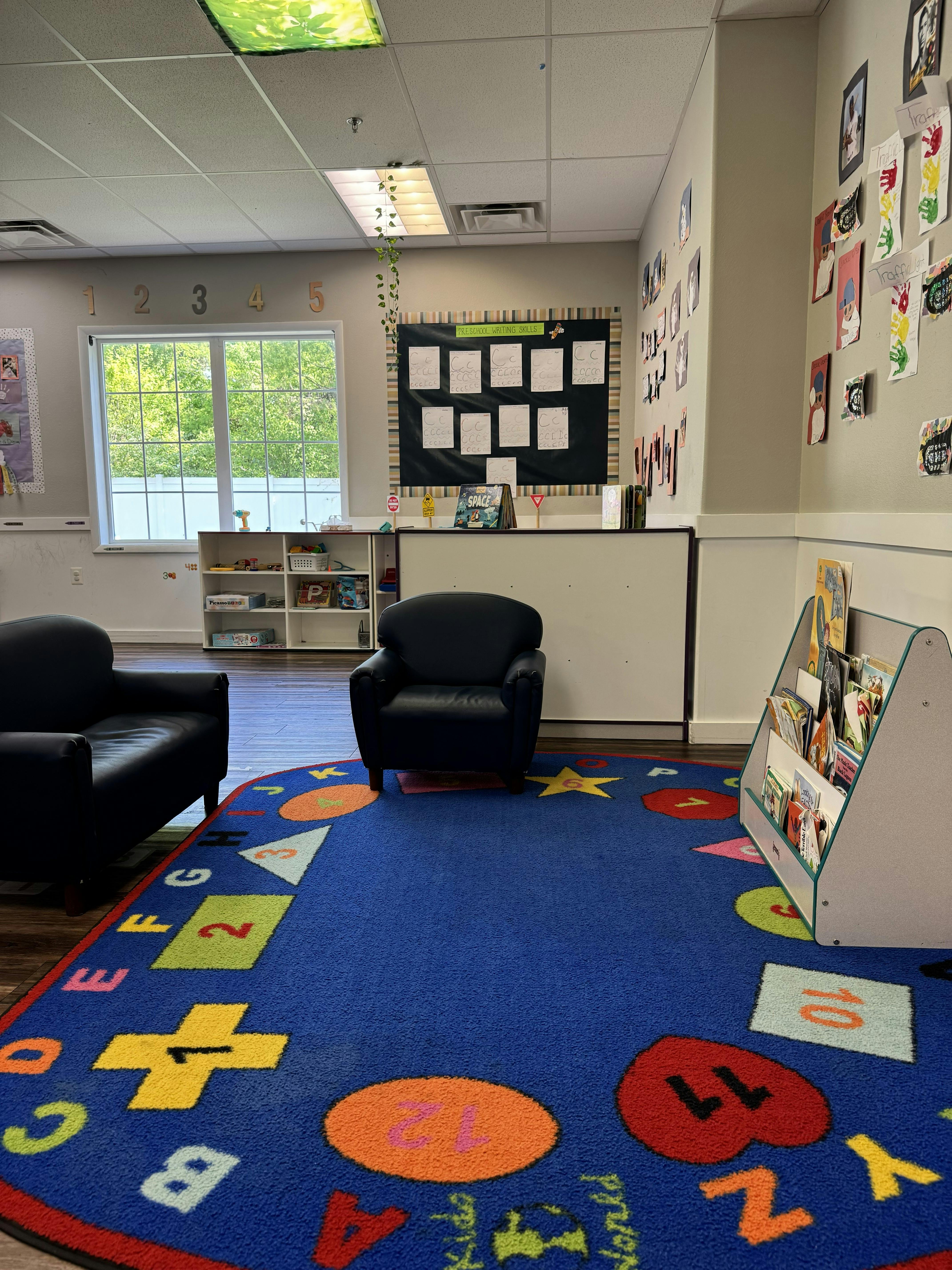 Classroom interior with small armchairs on a colorful letter and number rug