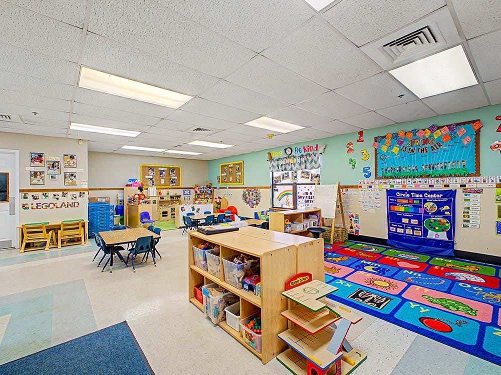 Colorful empty classroom with tables, chairs, and learning materials