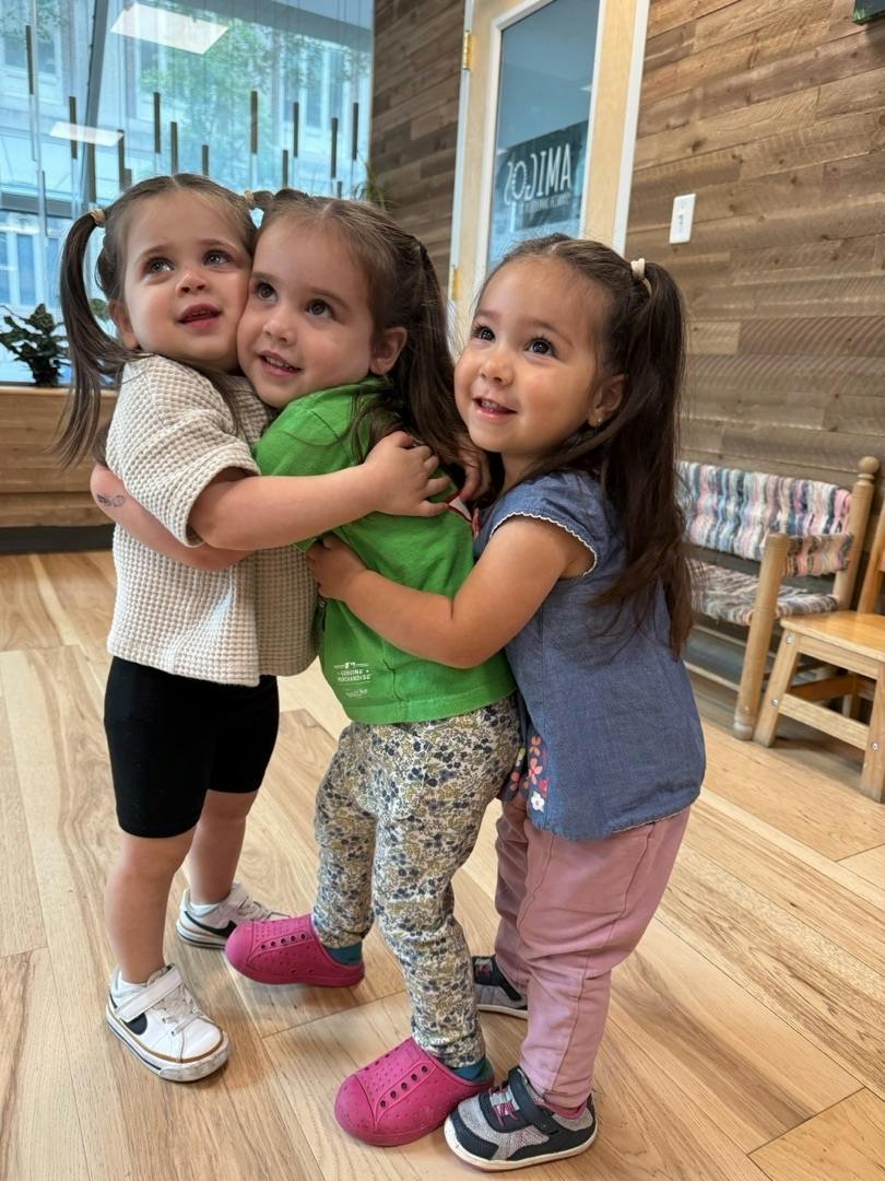 Three children hugging each other in a room
