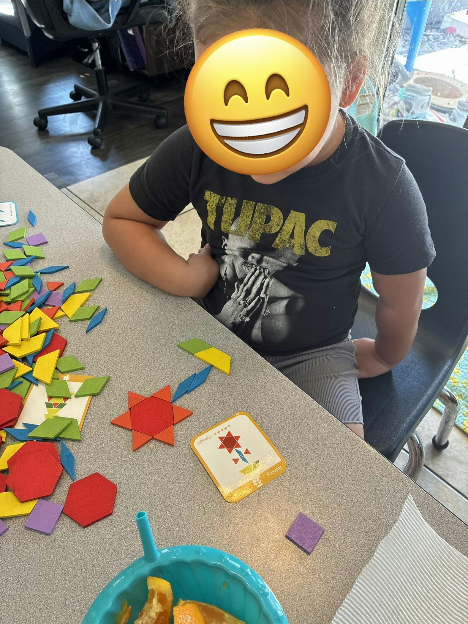 Child playing with geometric pattern blocks on a table