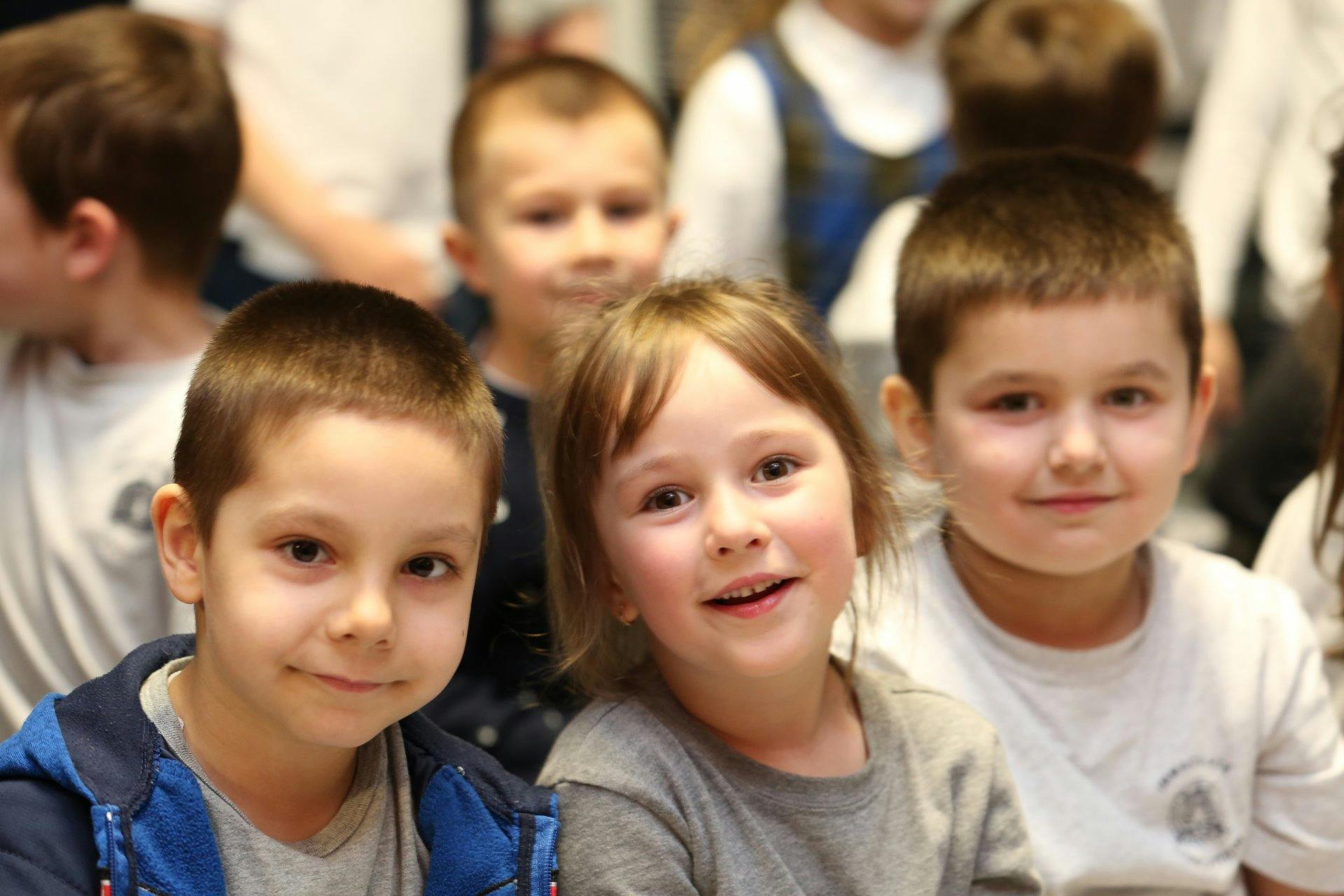 Three children looking forward, two in foreground