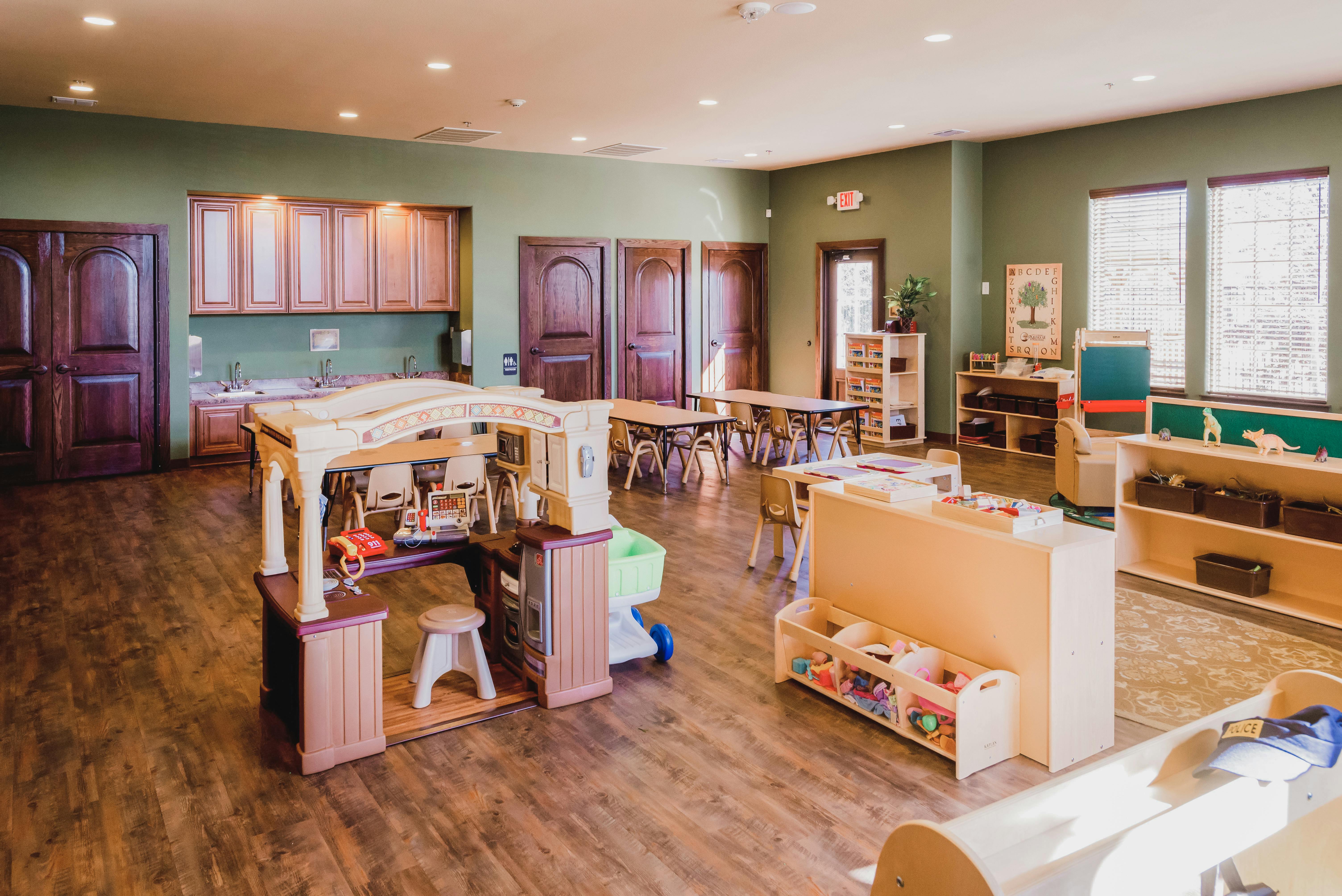 Empty classroom with play kitchen and tables