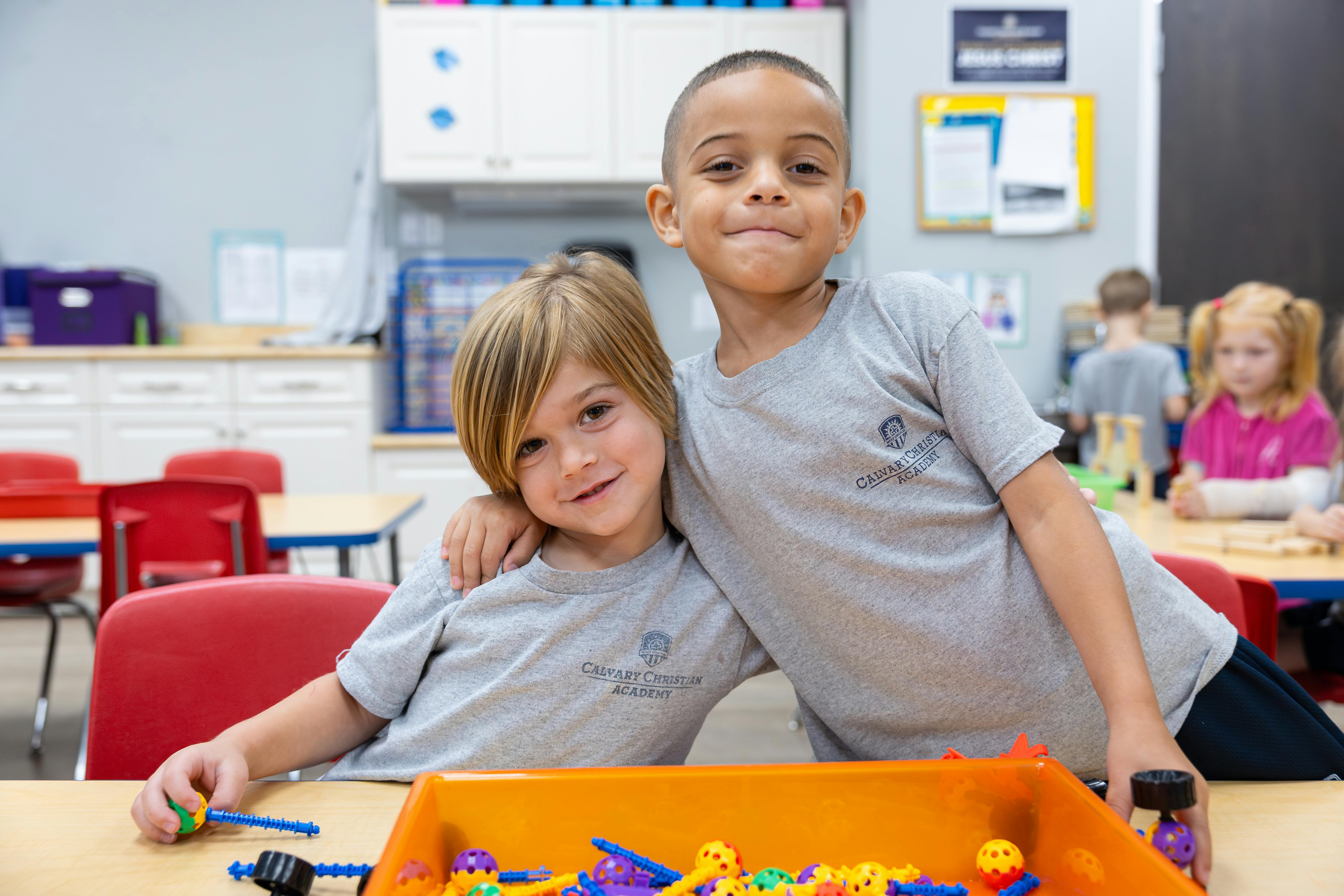 Two children wearing gray shirts with "Calvary Christian Academy" text
