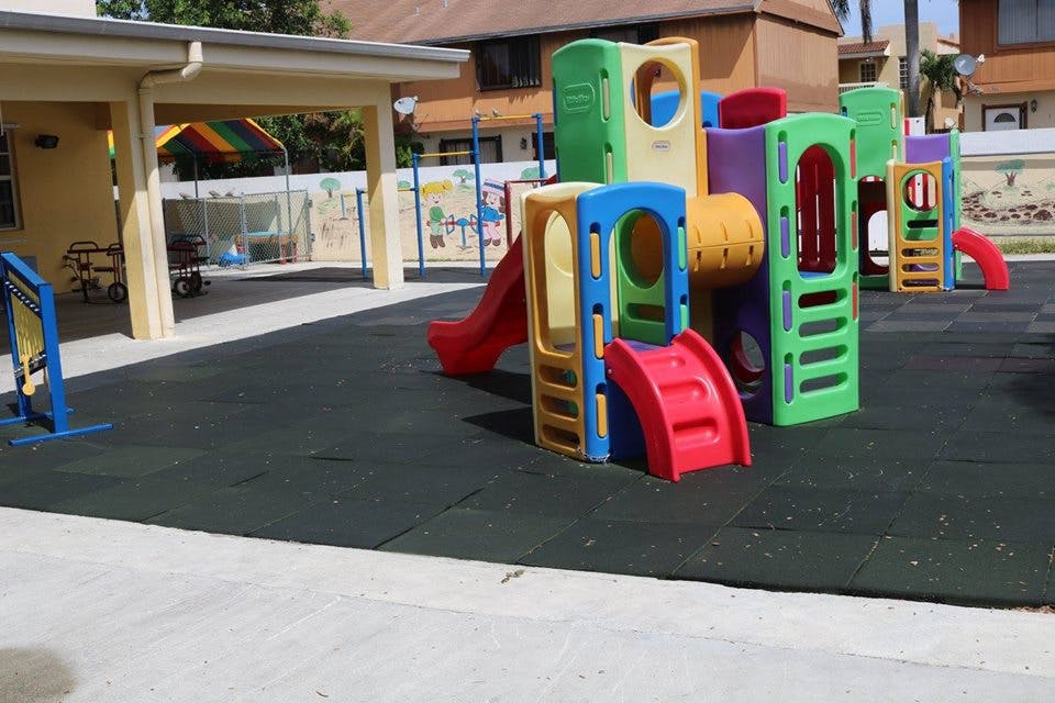 Colorful playground structure with slides on a dark padded surface