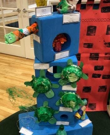 Craft display with blue blocks and green turtle-like figures
