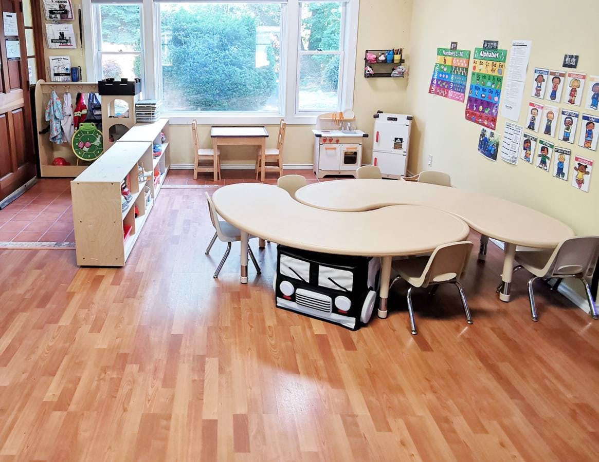 Classroom with tables, chairs, and shelves