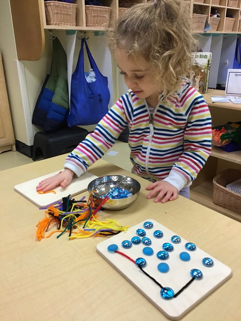 Child playing with craft materials on a table