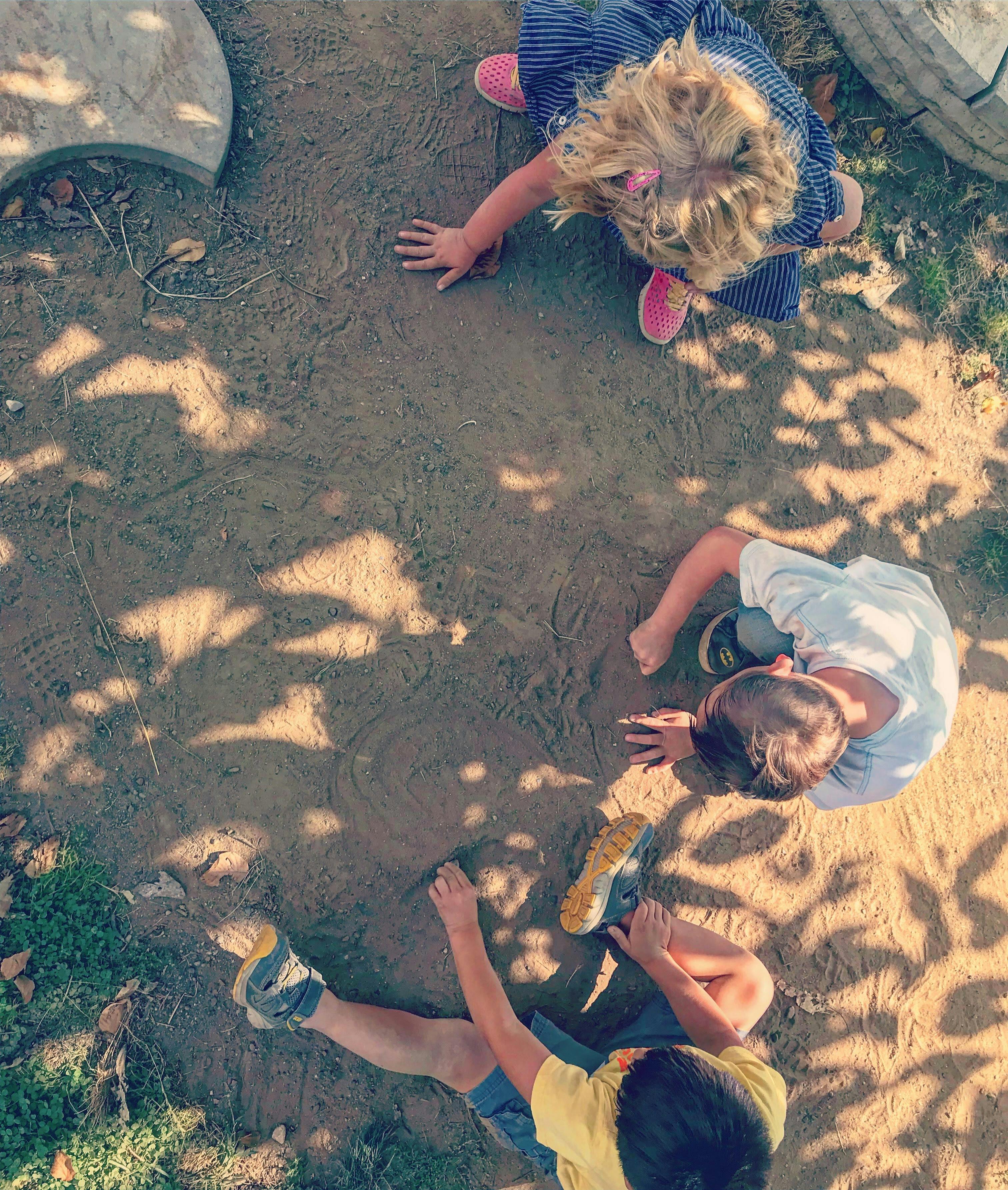 Three children playing on the ground
