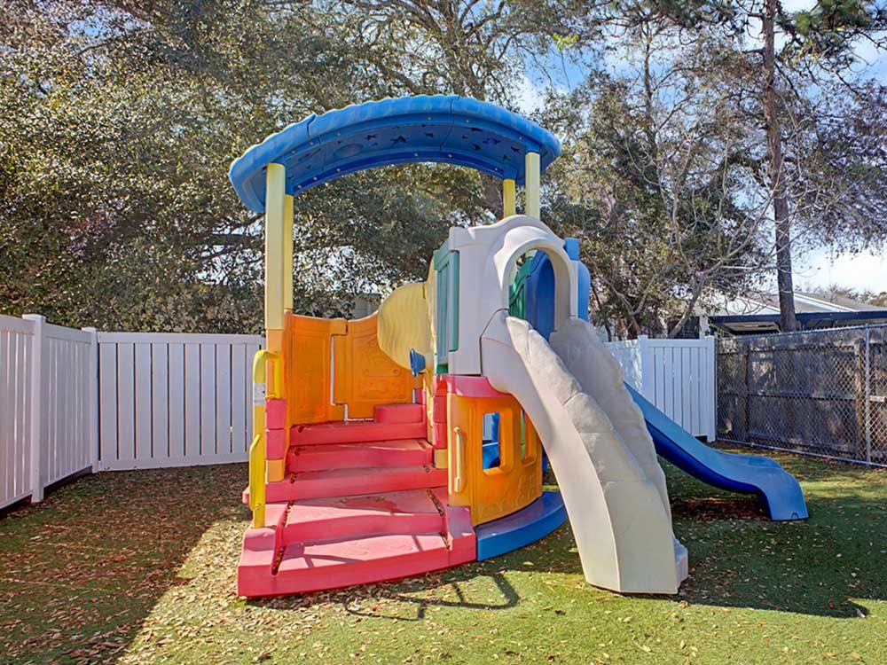 Colorful playground structure with slides on artificial turf