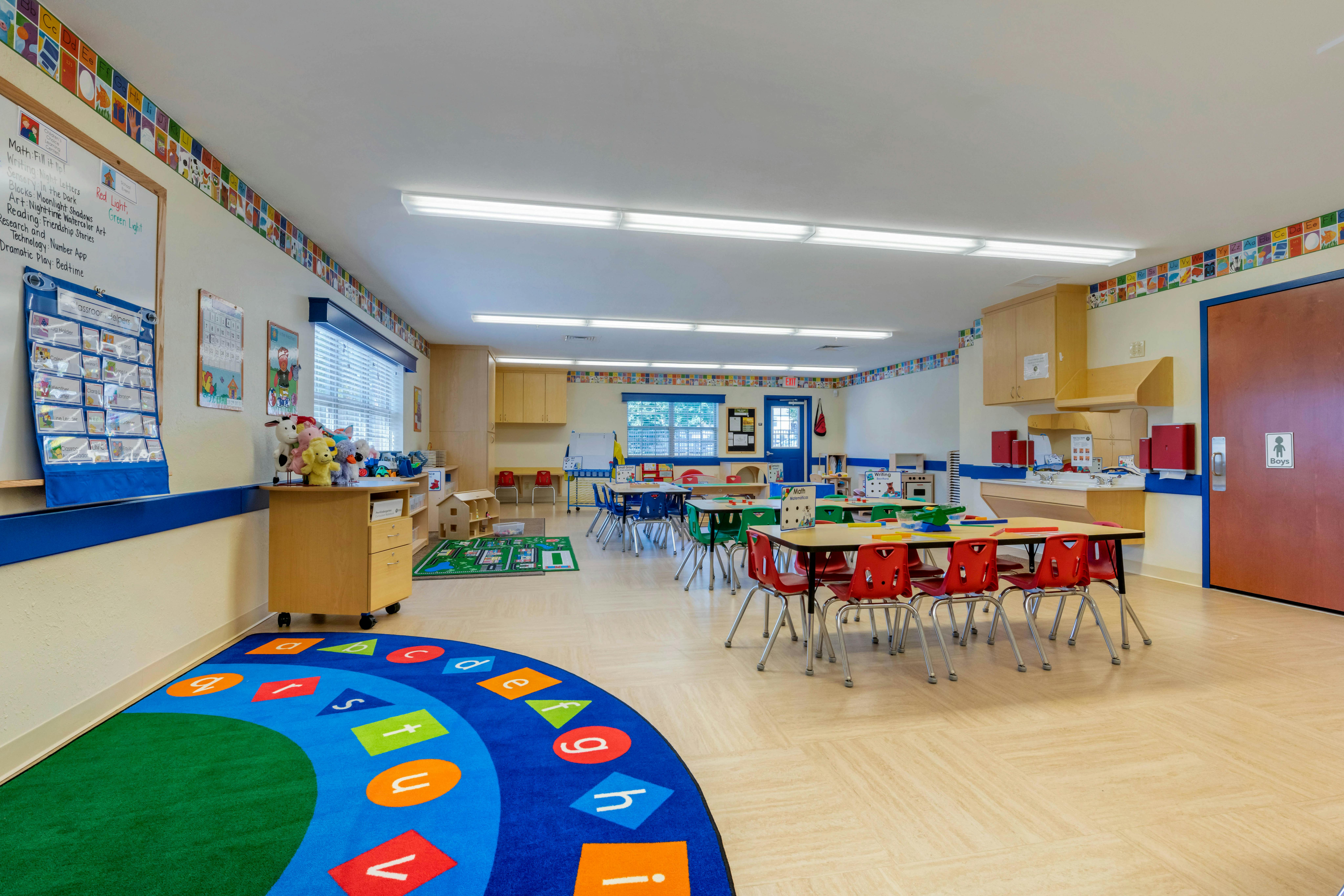 Empty colorful children's classroom with small tables and chairs