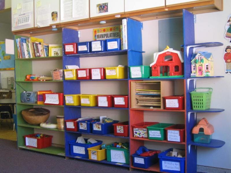 Shelves with colorful bins and toys in a classroom