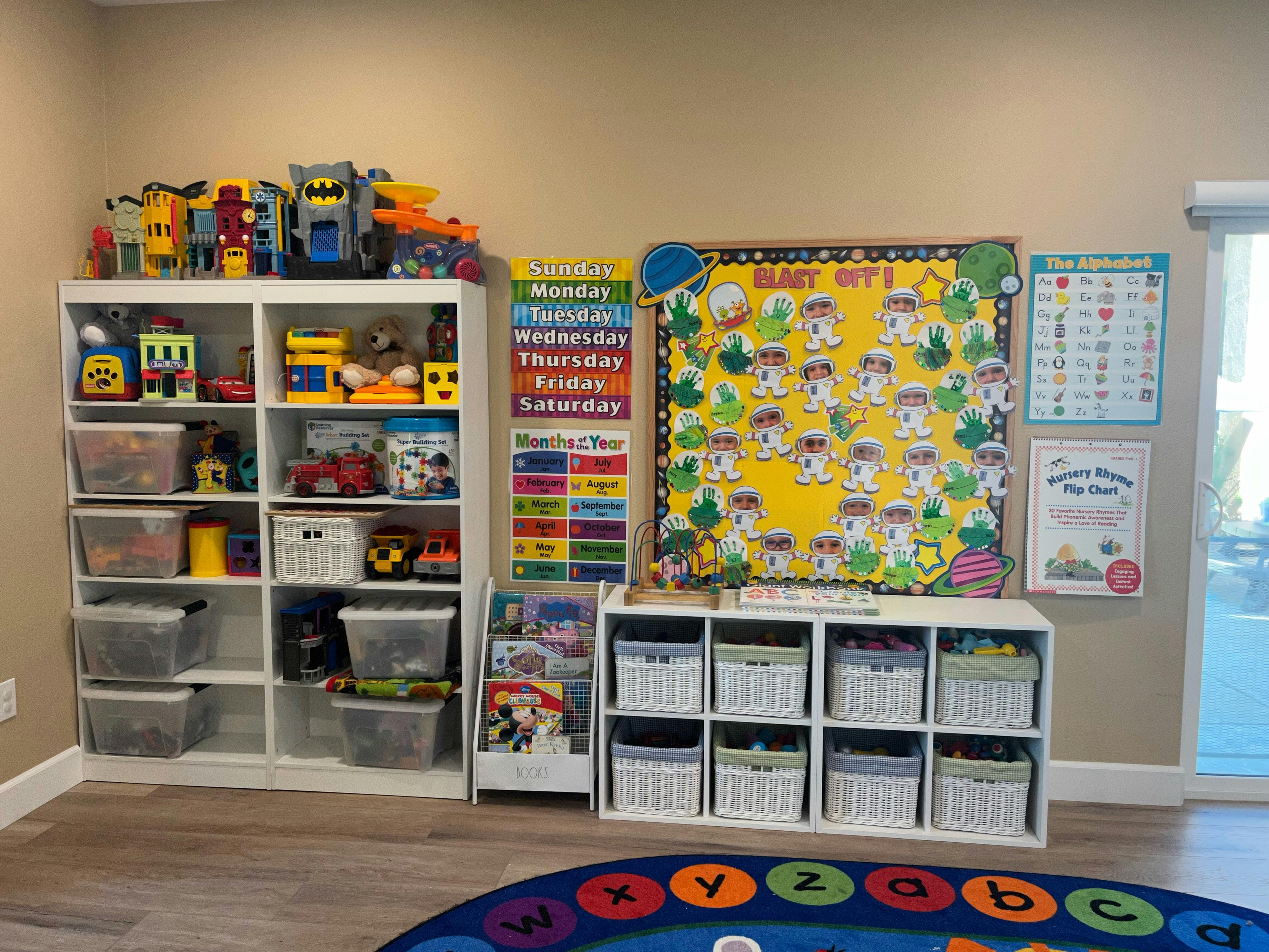 Children's playroom with toy shelves, storage bins, and educational posters