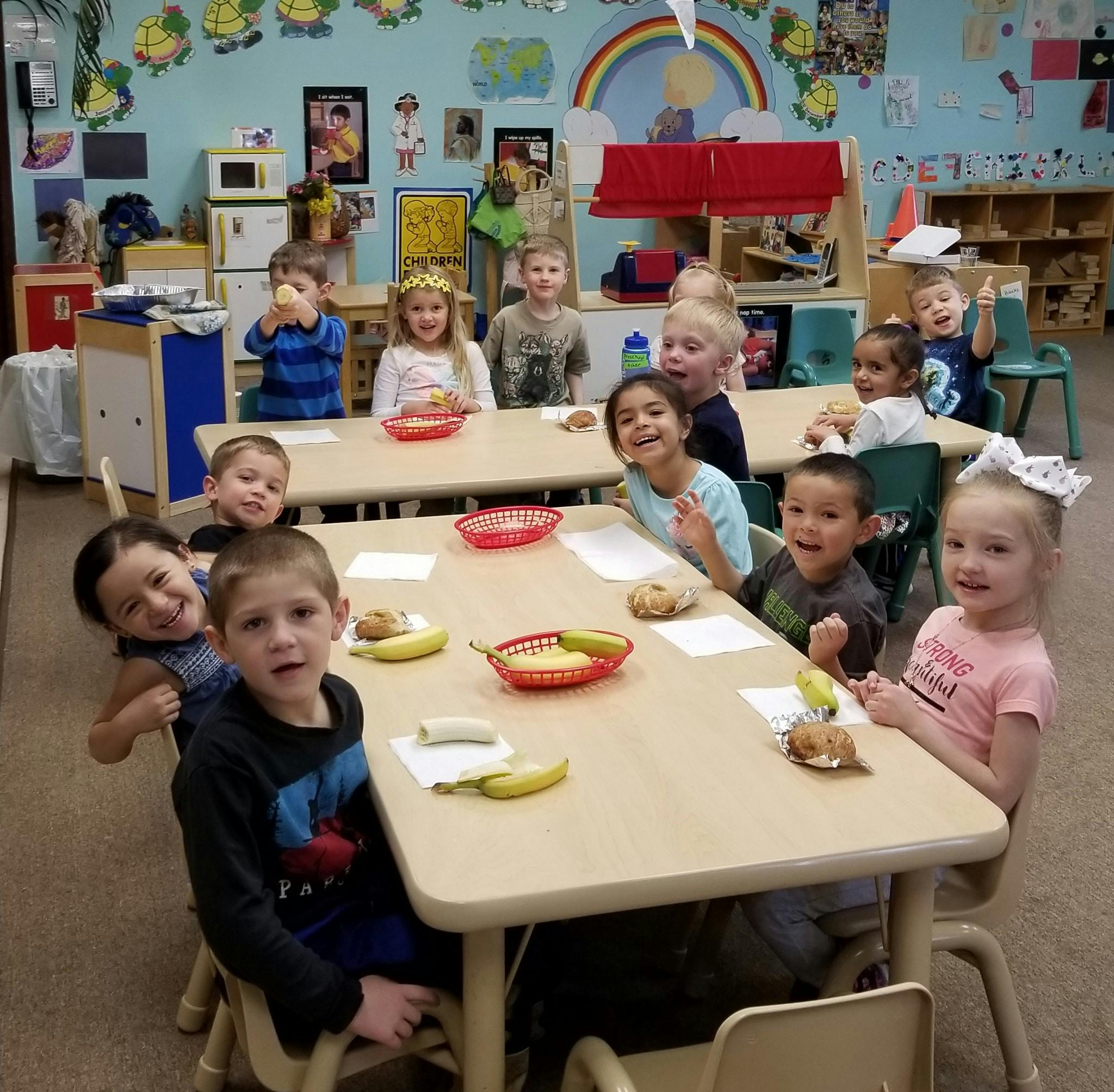 Children sitting at tables in a classroom