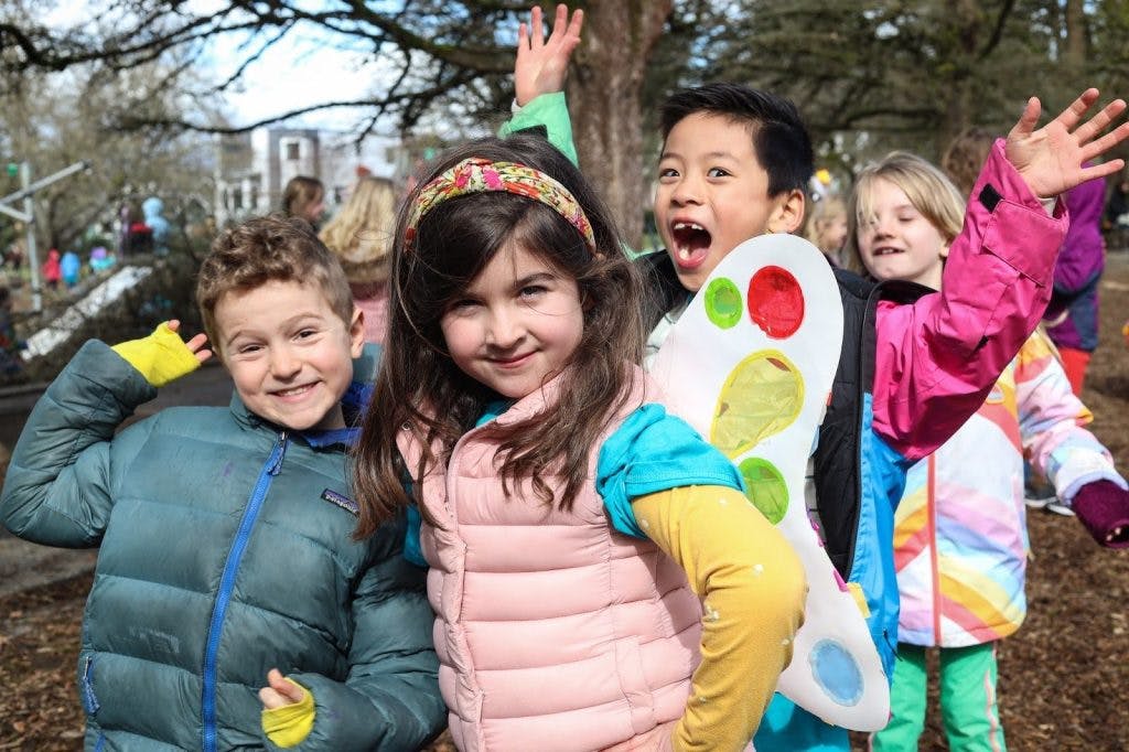 Group of children standing outdoors, one with butterfly wings