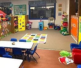 Classroom with tables, chairs, and colorful rug