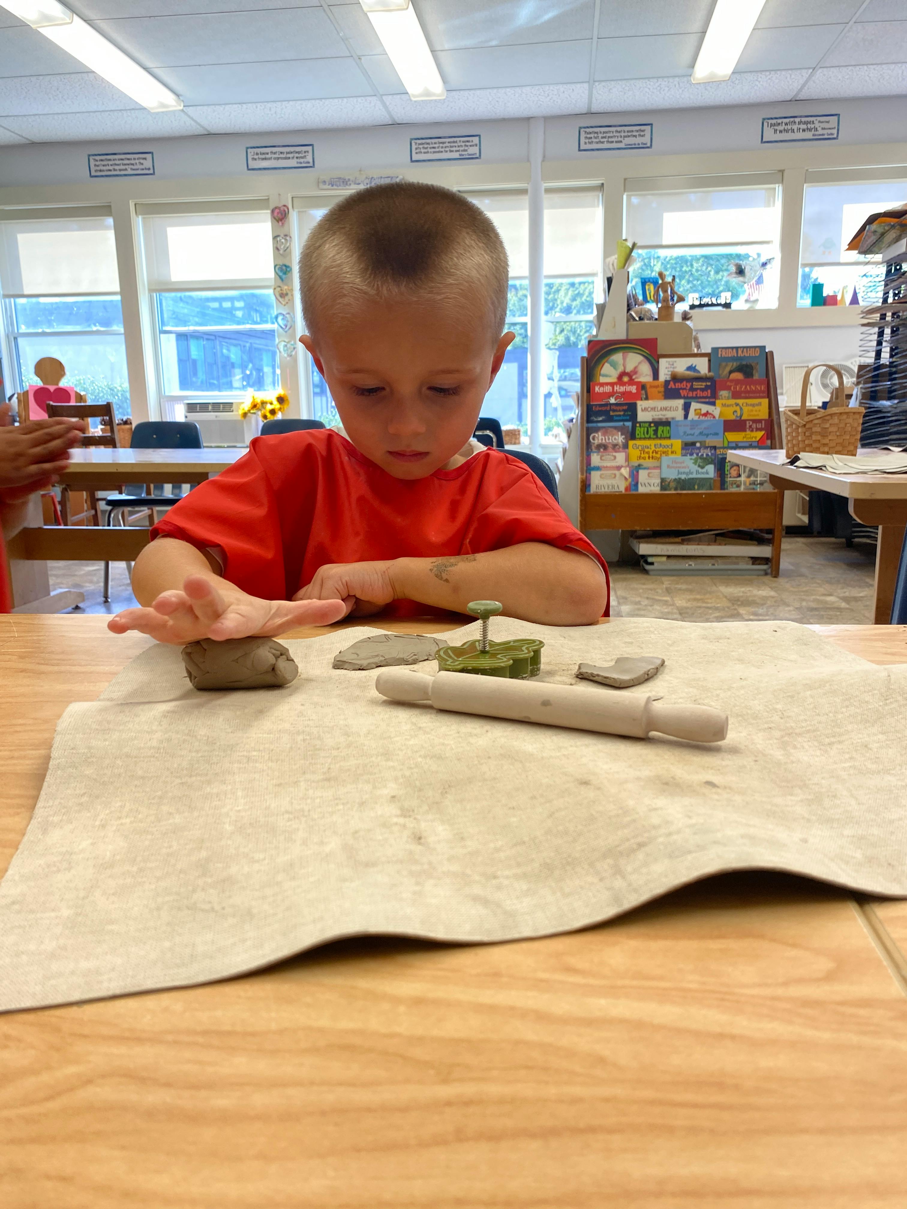 Child working with clay at a table