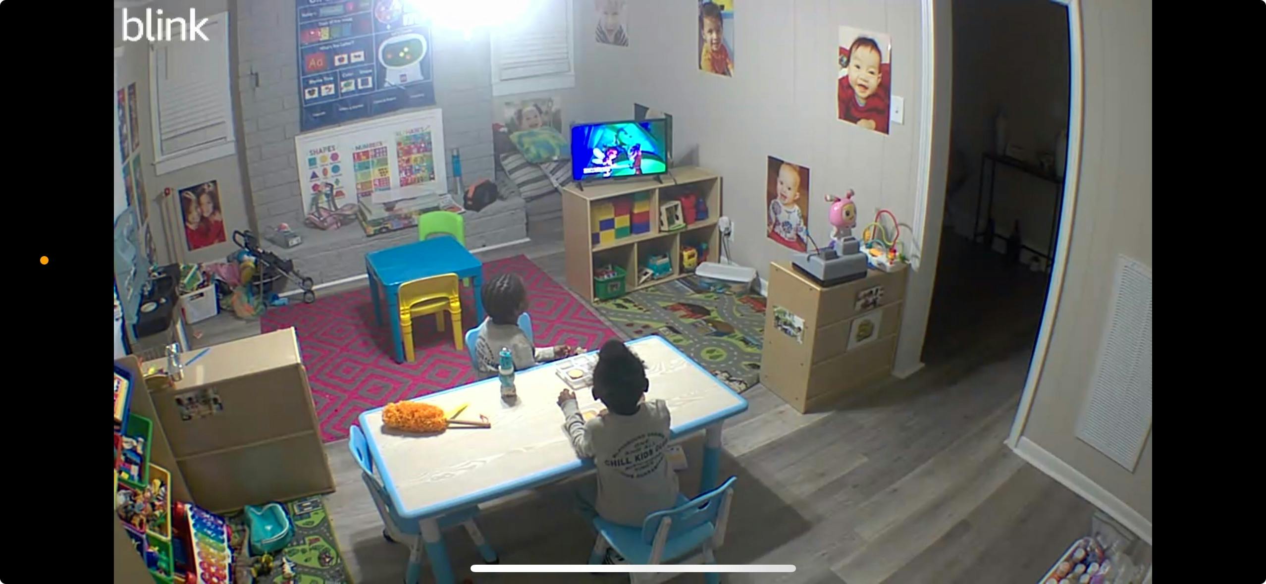 Two children sitting at tables in a room