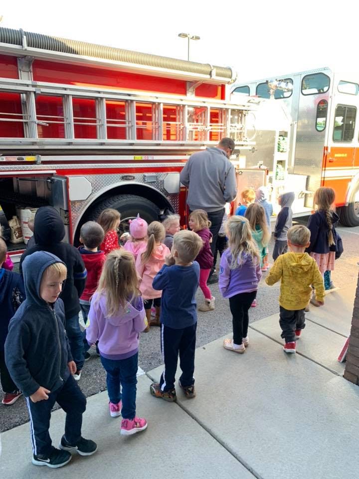Children and an adult gathered around a fire truck