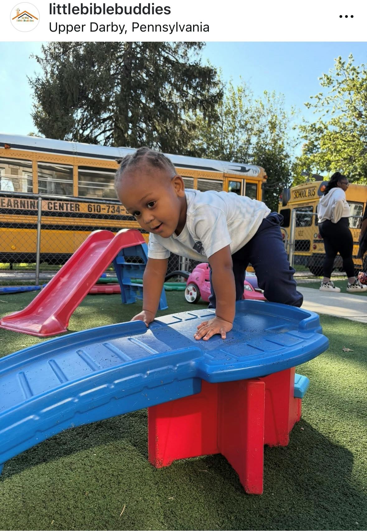 Child on hands and knees on a blue and red playground structure