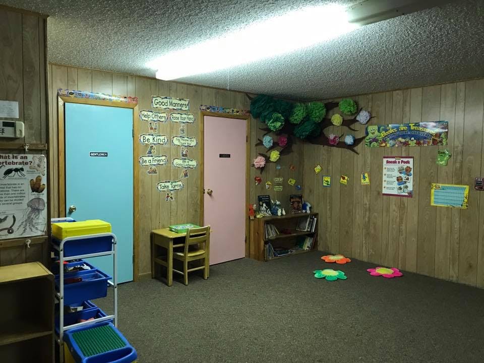 Classroom with two doors, small table and chairs, and wall decorations