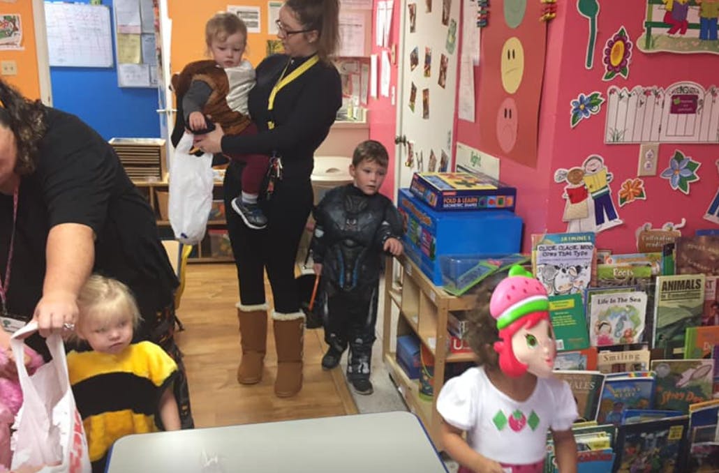 People and children in costumes in a classroom