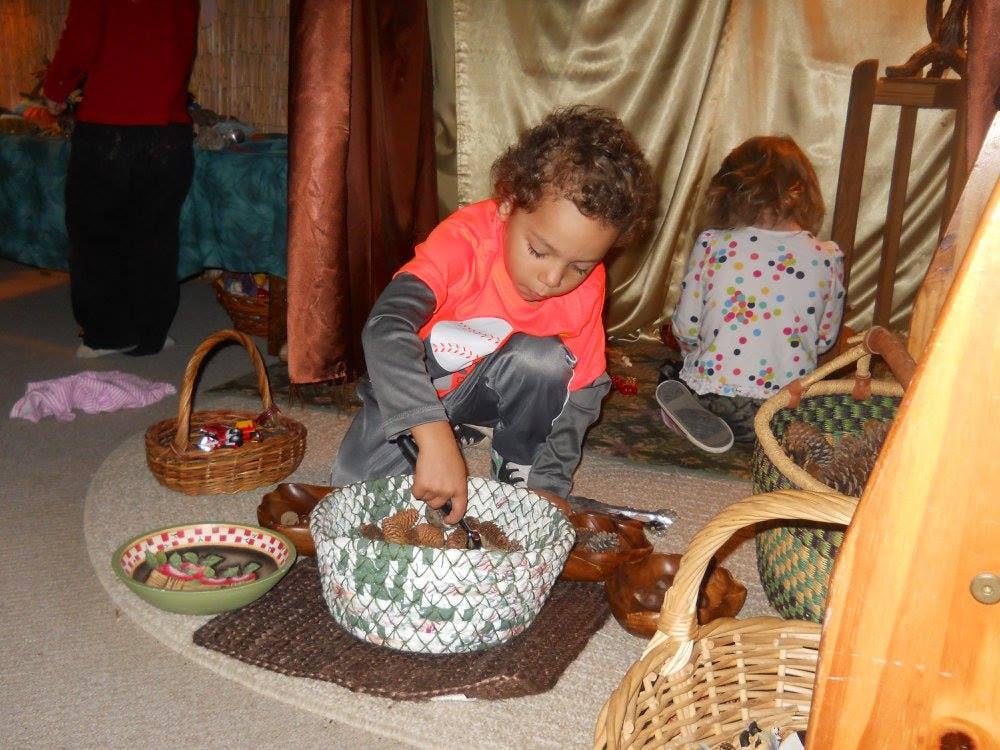 Child kneeling and reaching into a basket