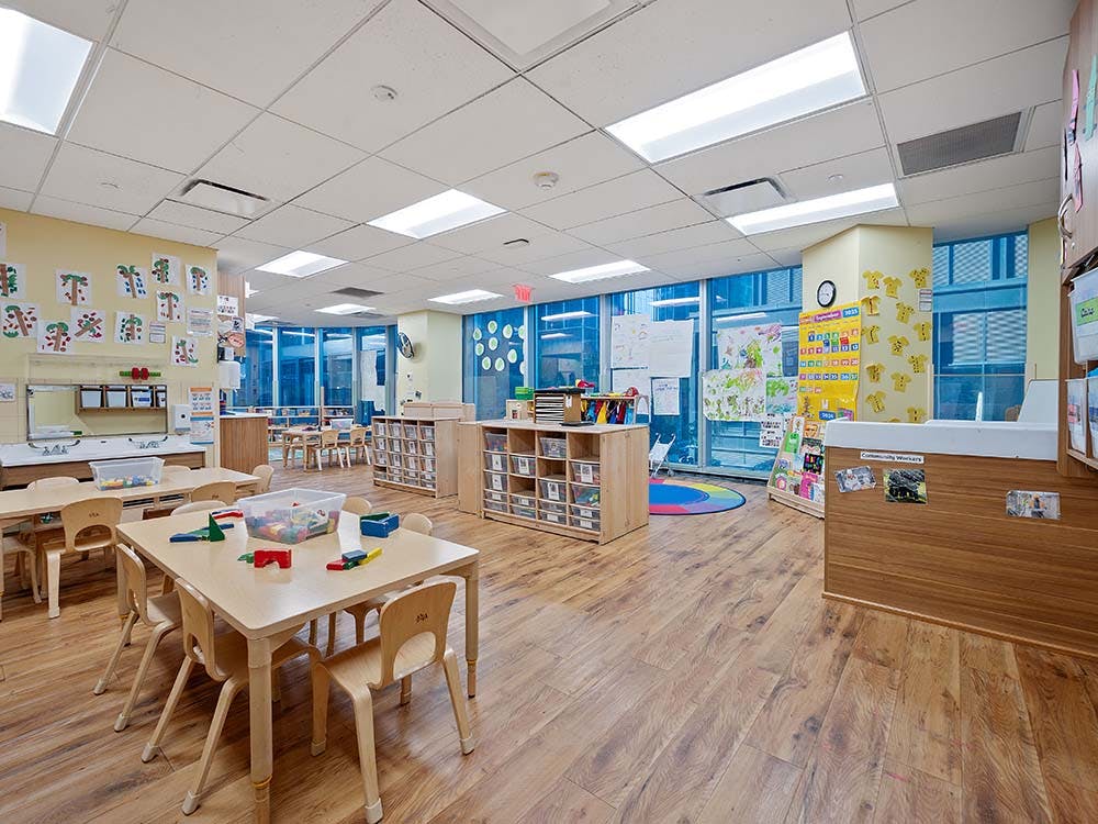 Classroom with small wooden tables and chairs, toys on tables