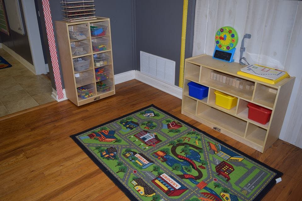 Playroom with a road map rug and two wooden storage shelves