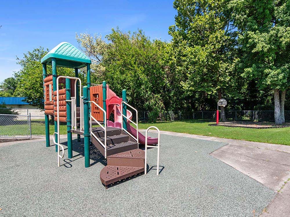 Playground with steps, platforms, and a slide on a rubberized surface