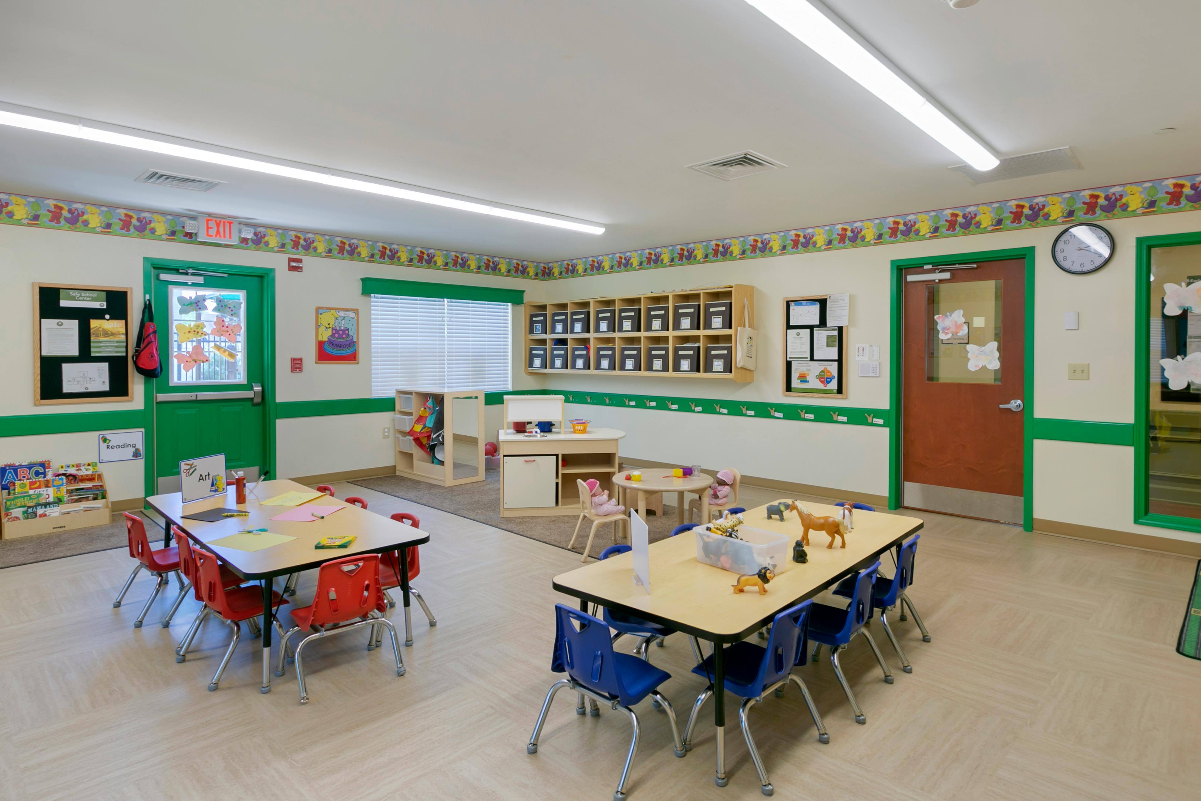Classroom with child-sized tables and chairs, shelves, and colorful decor