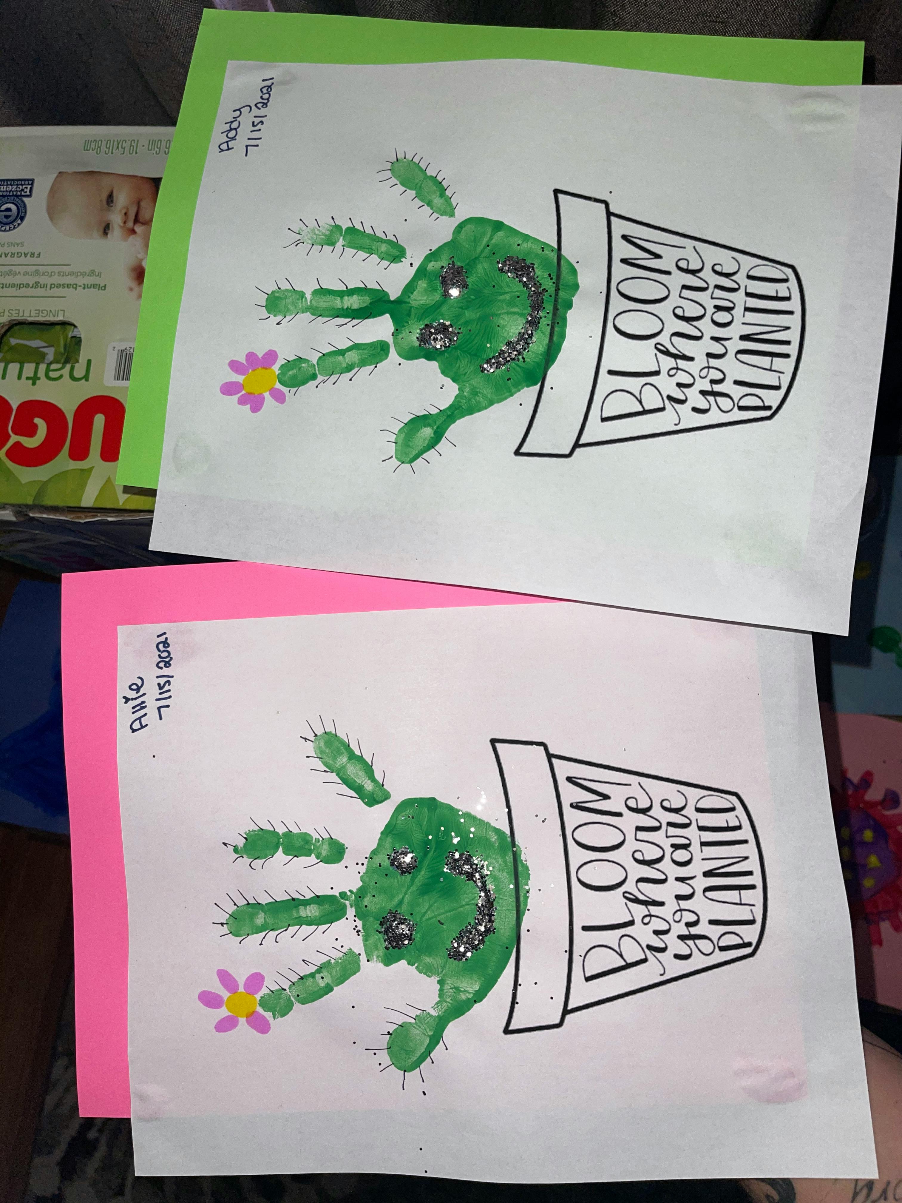 Two child's handprint crafts with green paint and glitter, text "Bloom where you are planted"