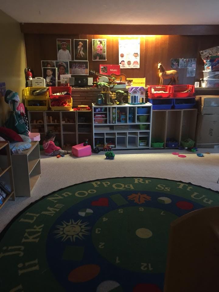 Child playing on the floor in a room with shelves of toys