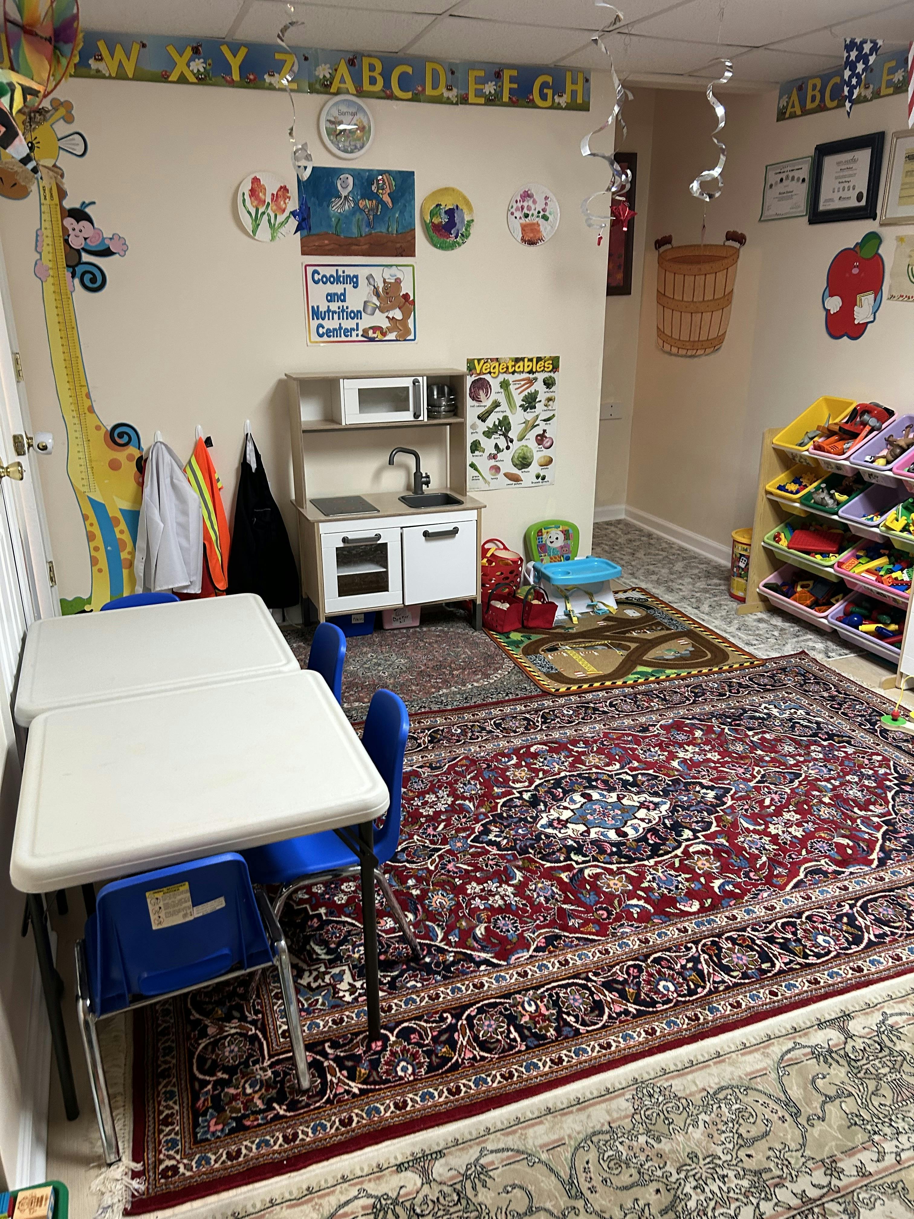 Playroom with child-sized tables and chairs, toy kitchen, and storage shelves