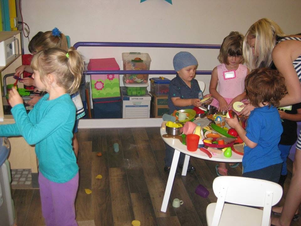Adult and children playing with toys in a room