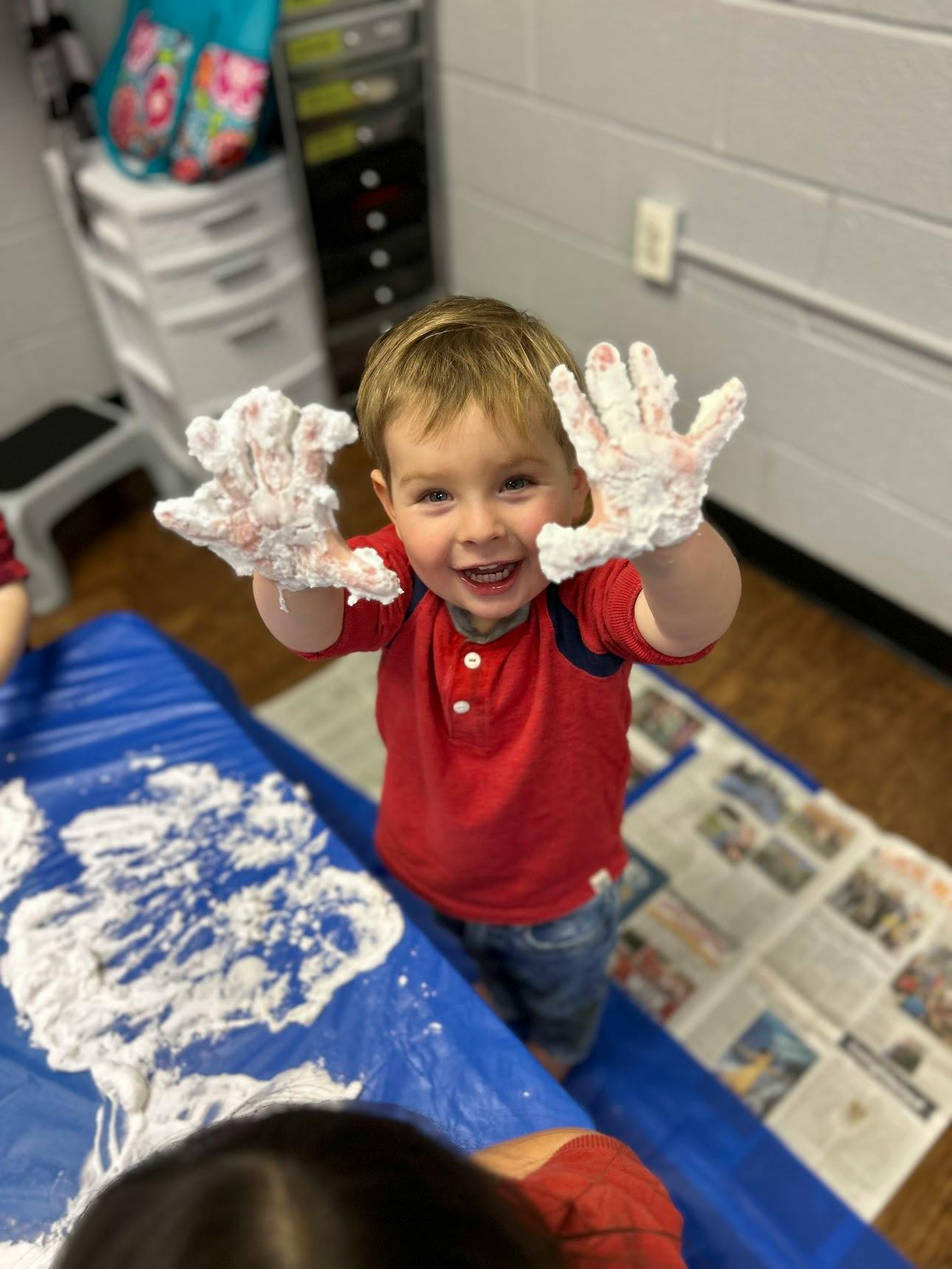 Child with hands covered in white foam
