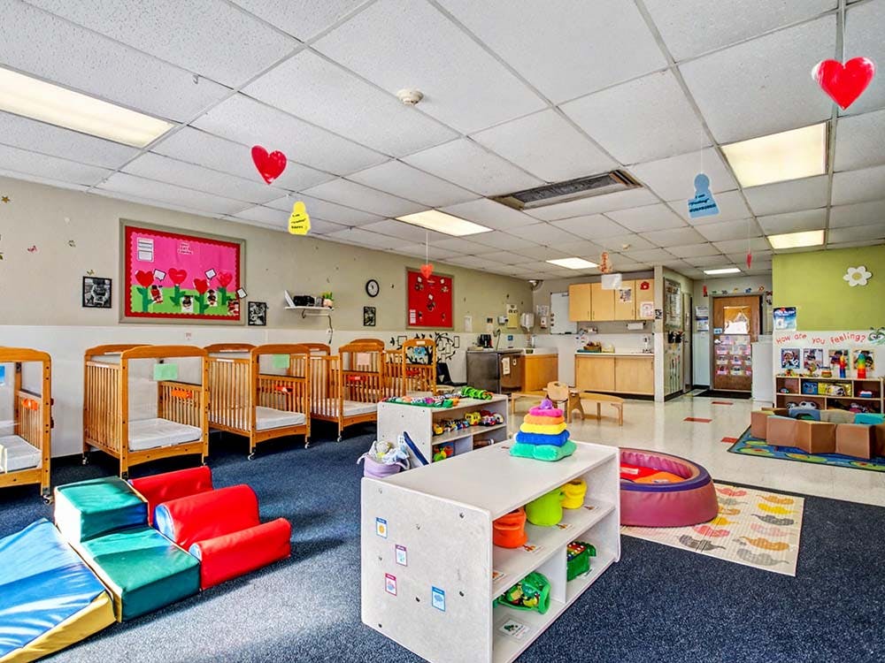 Cribs and play area in a daycare or nursery room