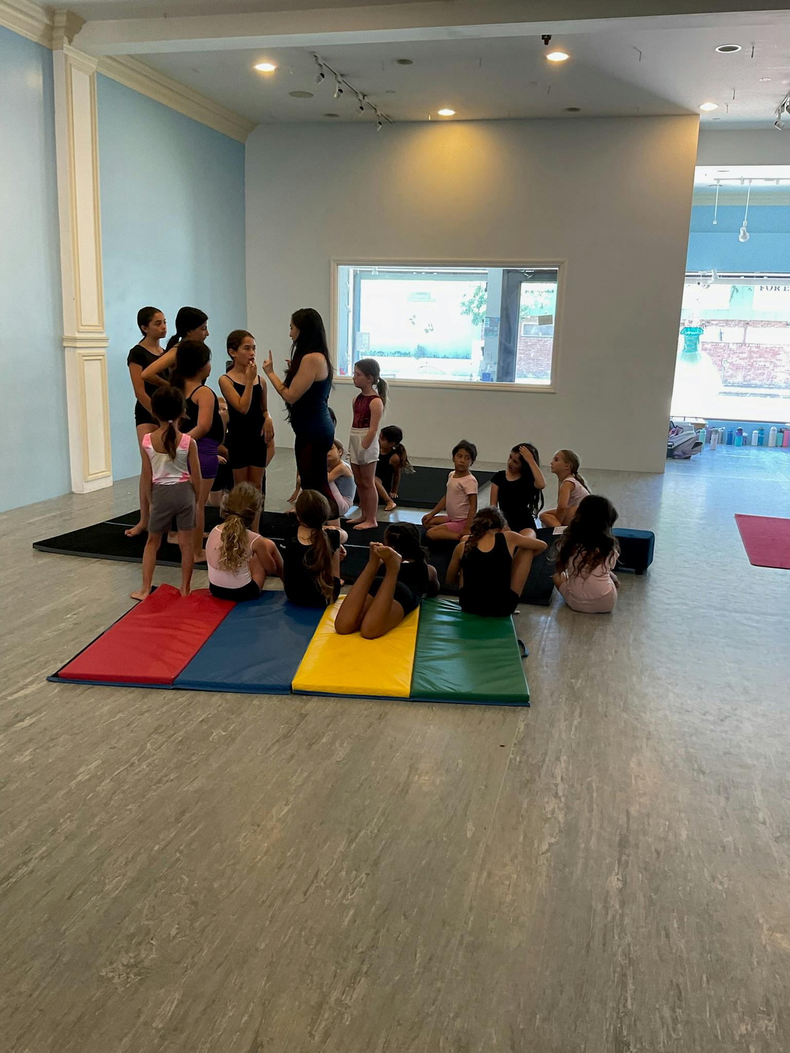 Adult person instructing a group of children in a studio