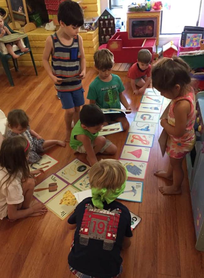 Children playing with picture cards on a wooden floor