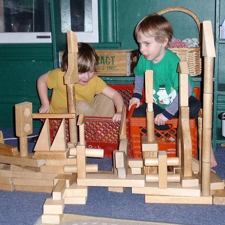 Two children playing with wooden blocks