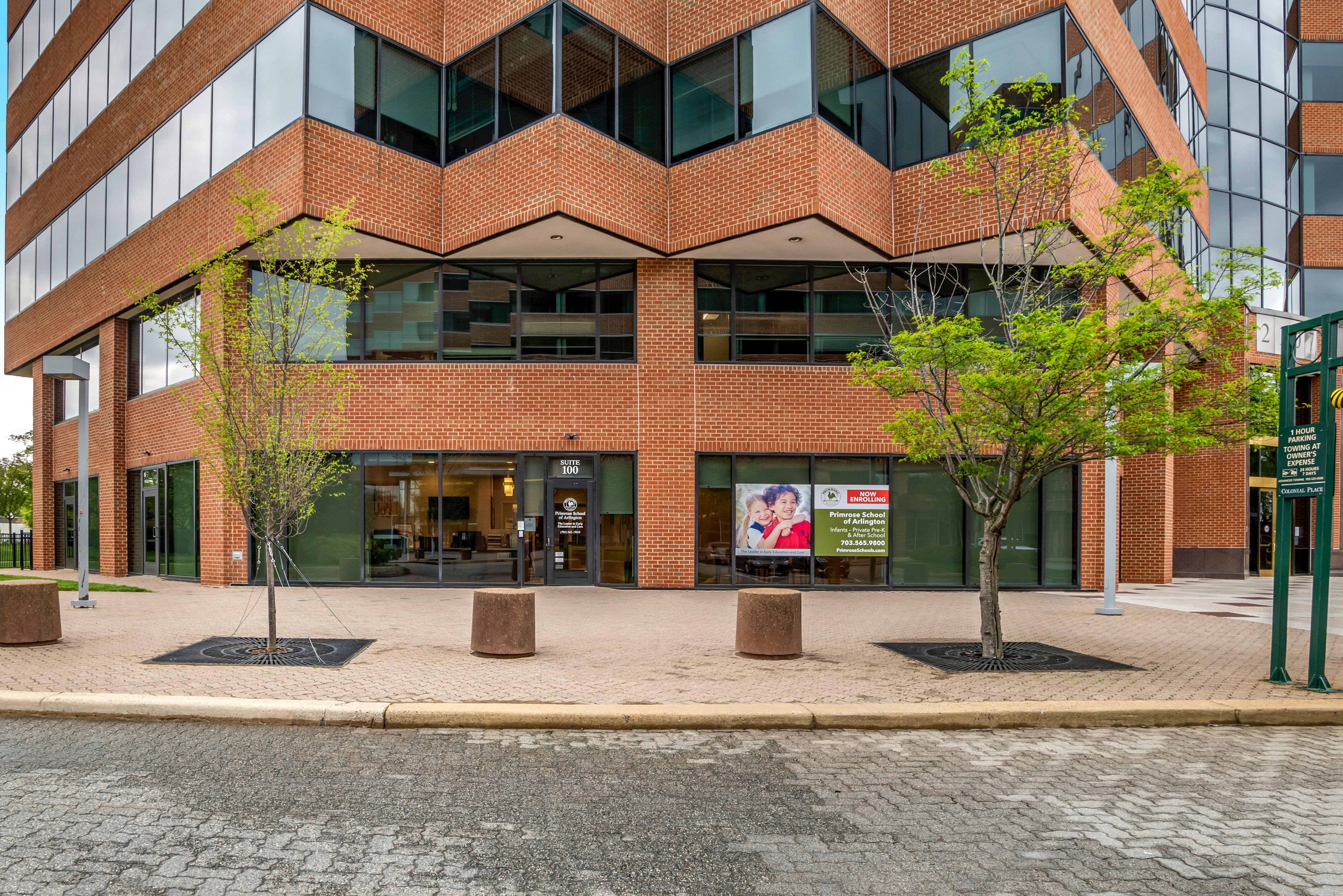 Exterior of a brick building with many windows and two small trees